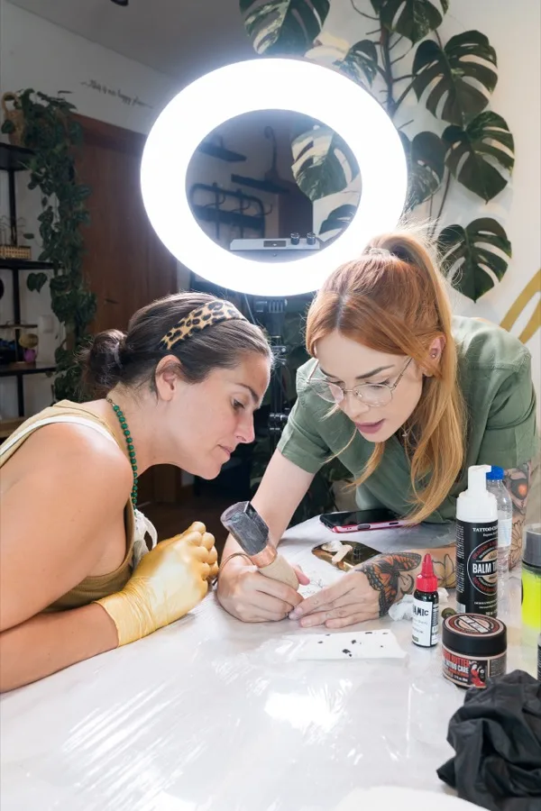Aluna tatuando com acompanhamento próximo